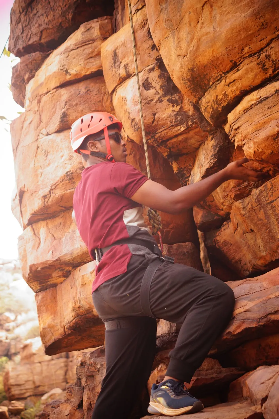 A student climbing a rock face at Gandikota, Andhra Pradesh