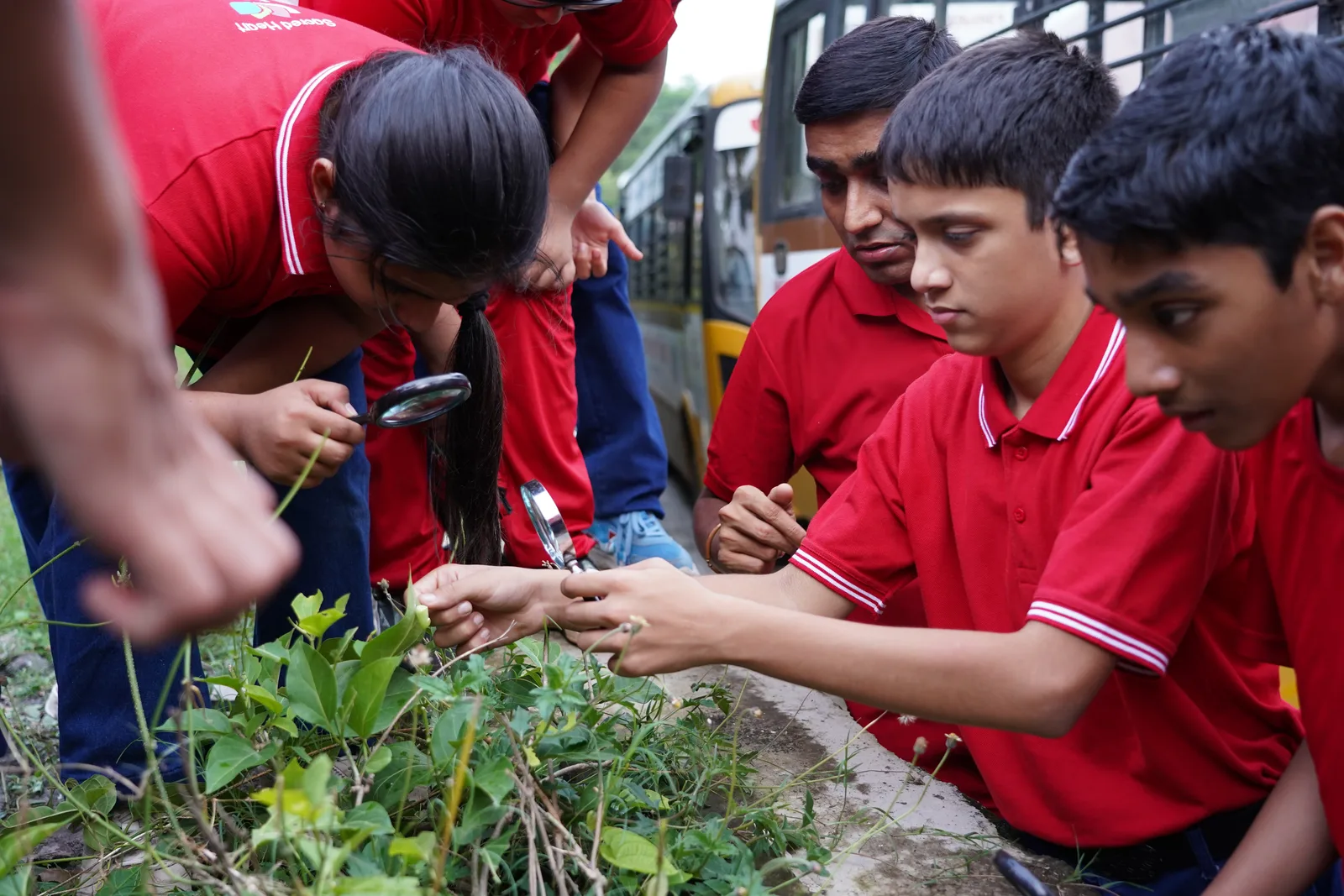 A student examining a plant with a magnifying glass