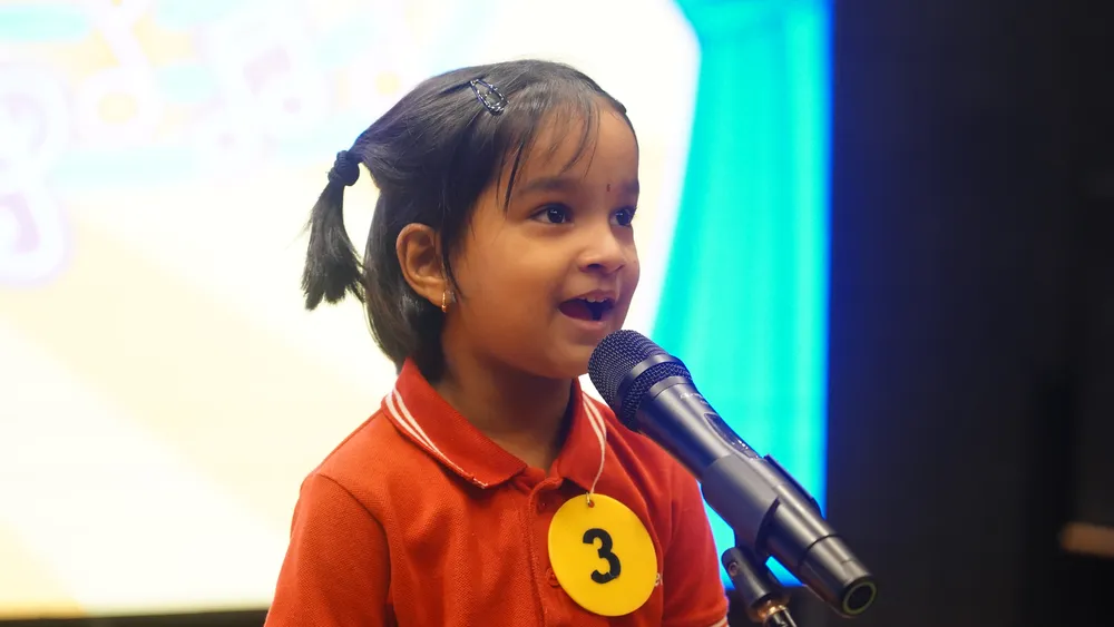 A Pre-Primary child singing into a microphone at the Singing Competition