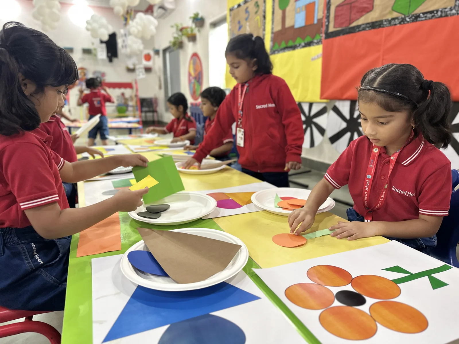 Pre-Primary children finger-painting on a large sheet of paper