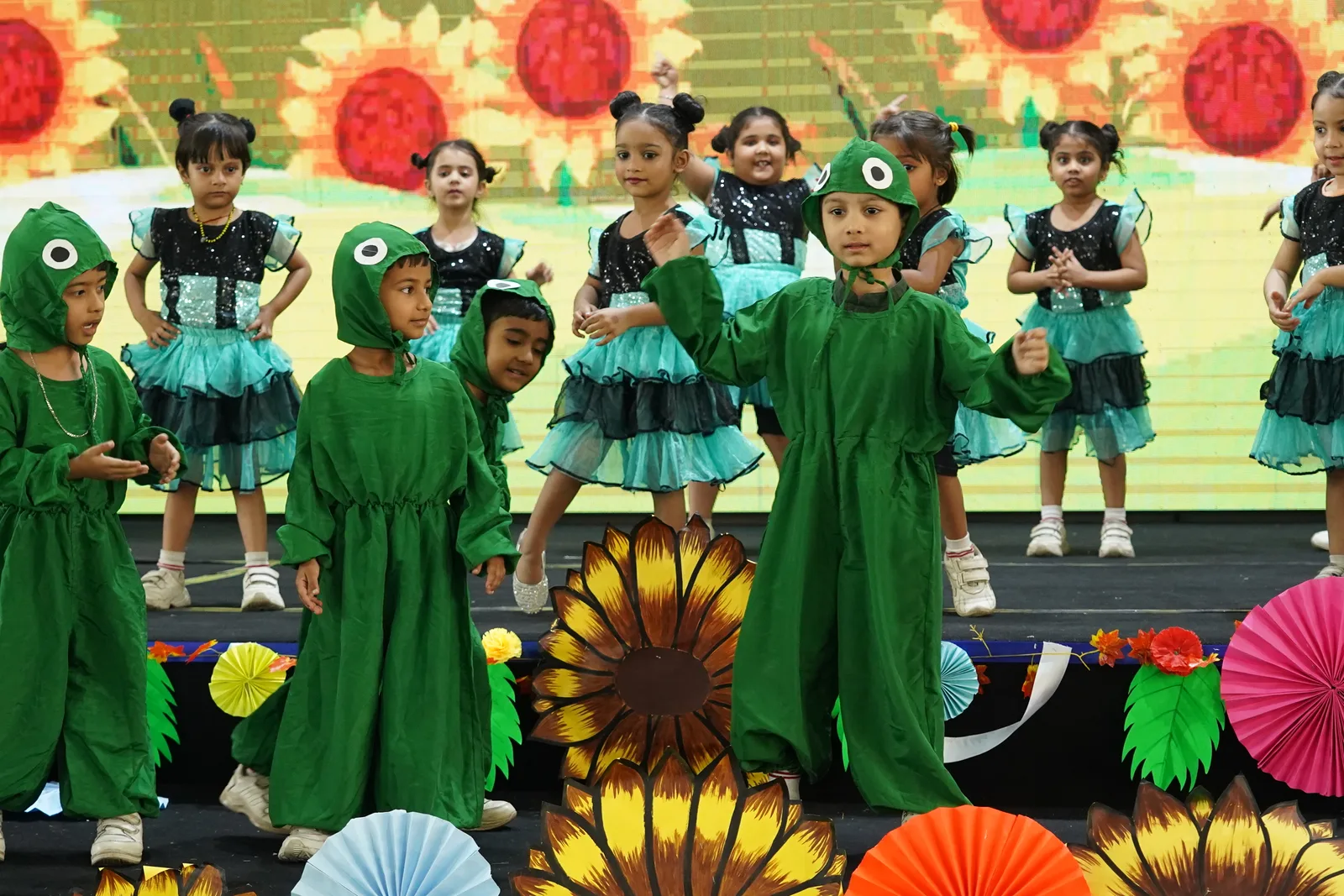 Pre-Primary children in frog costumes performing on stage
