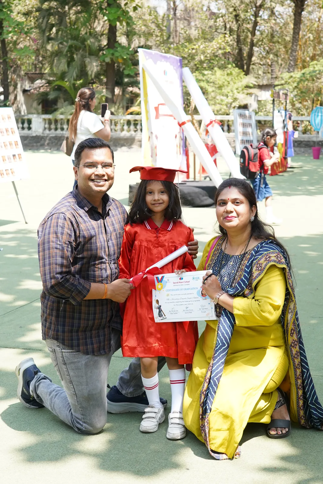 Parents celebrating with their child in a graduation cap