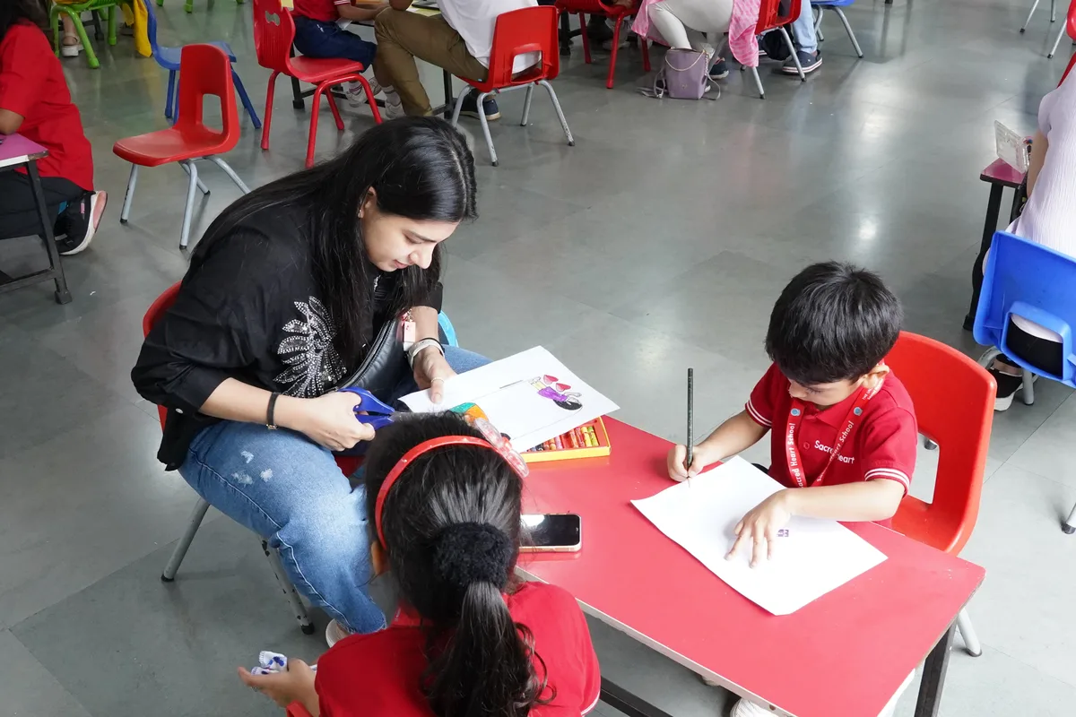 A parent and child drawing together at a table