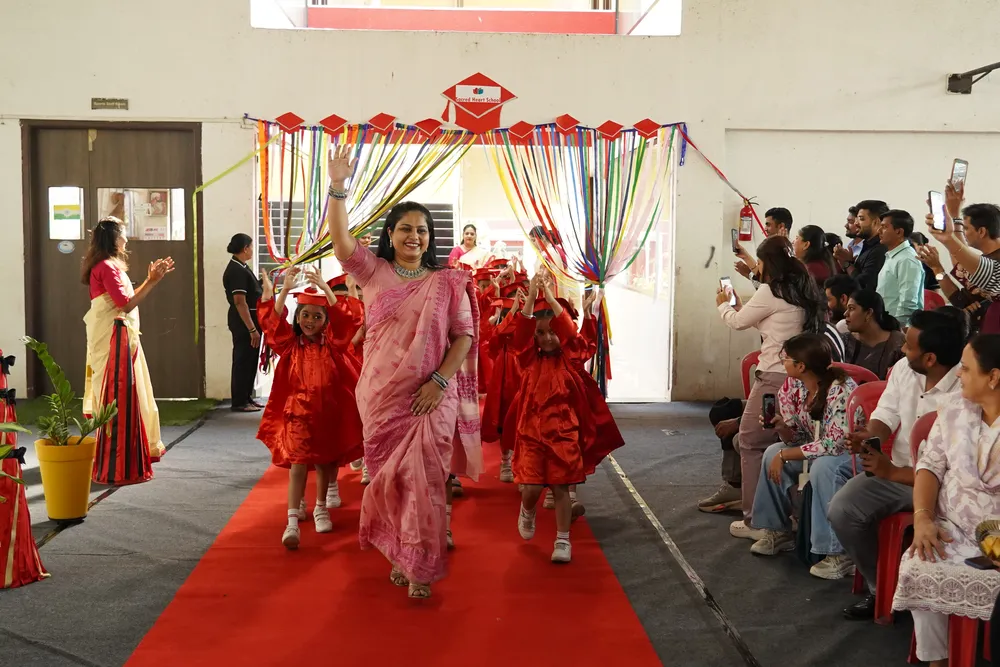 Graduates arriving along a red carpet at the Graduation Day ceremony