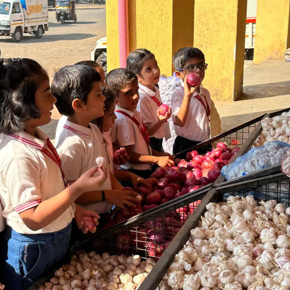 Pre-Primary children examining onions and garlic on a market visit
