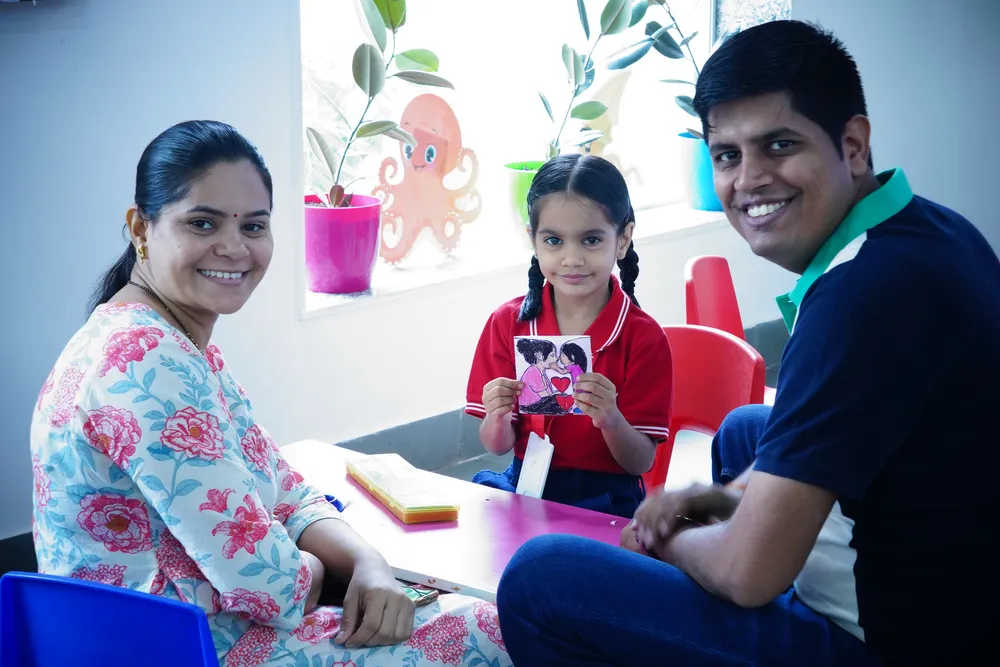 Two parents and their child at a classroom activity table