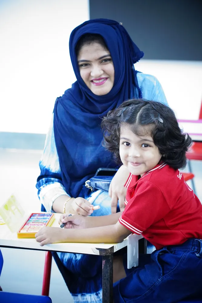 A smiling parent and child working on an activity together