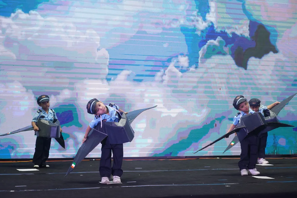 Children in soldier and pilot costumes on stage
