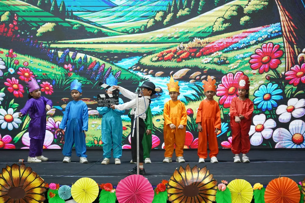Children in colourful costumes on a flower-meadow stage set