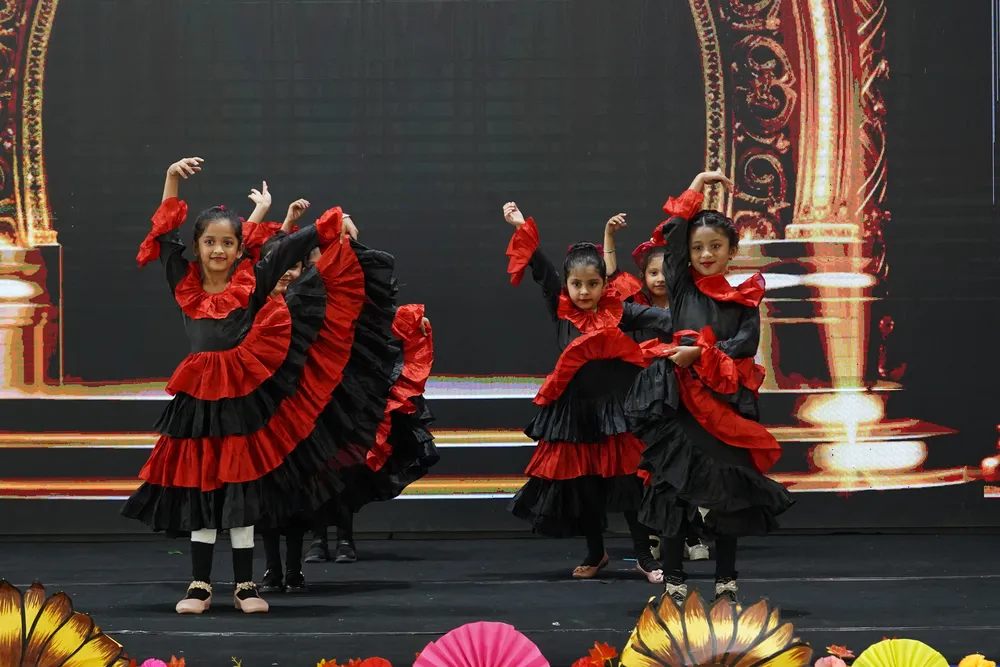 Children in red and black flamenco-style costumes on stage