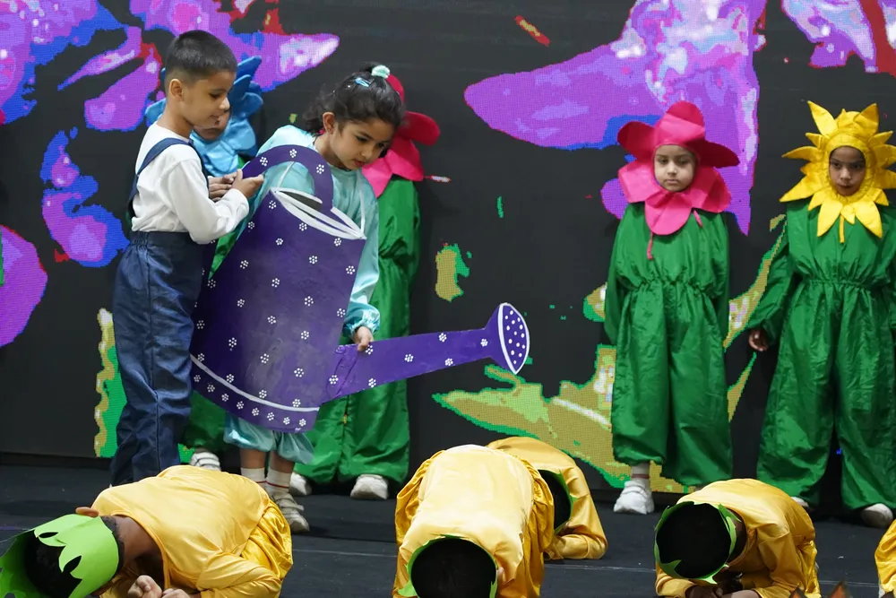 Children performing a garden-themed act on stage