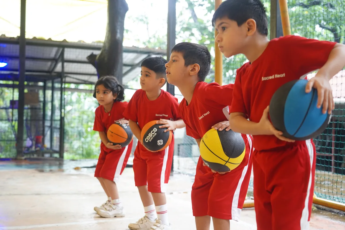 Pre-Primary children holding basketballs during a Sports Day practice