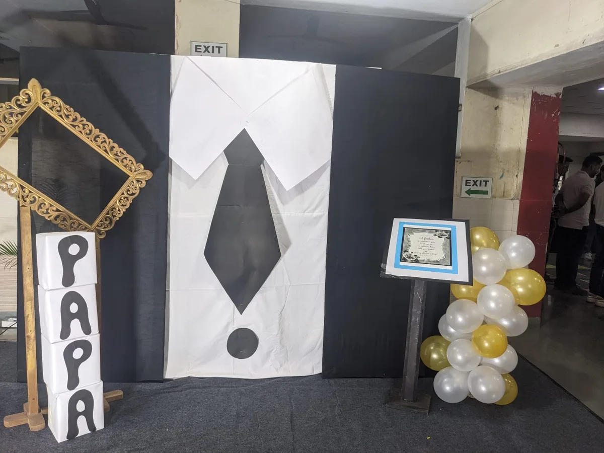 A tie-shaped Papa art installation decorated with balloons