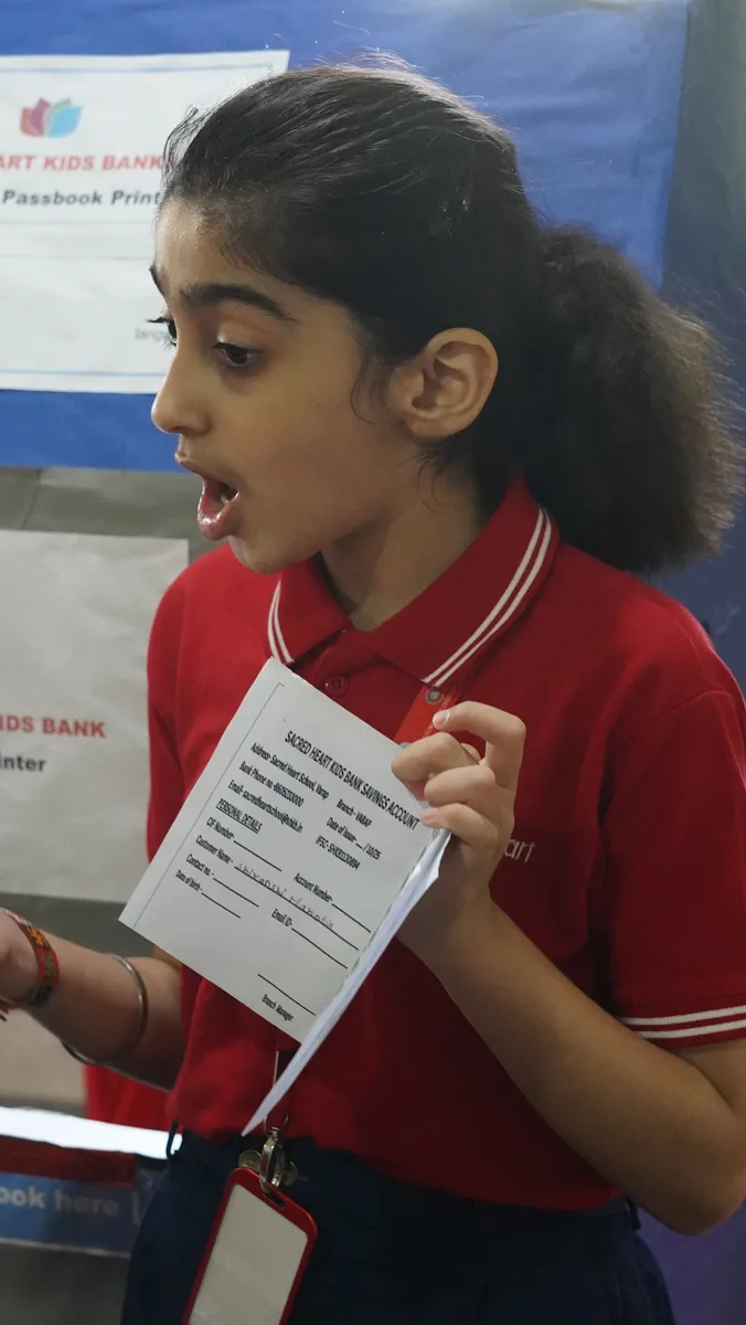 A Primary student reading from a slip during the bank role-play