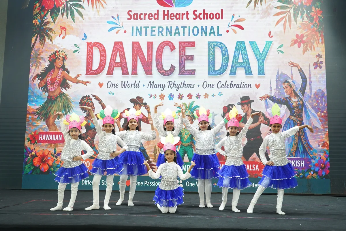 Primary students posing on stage at International Dance Day