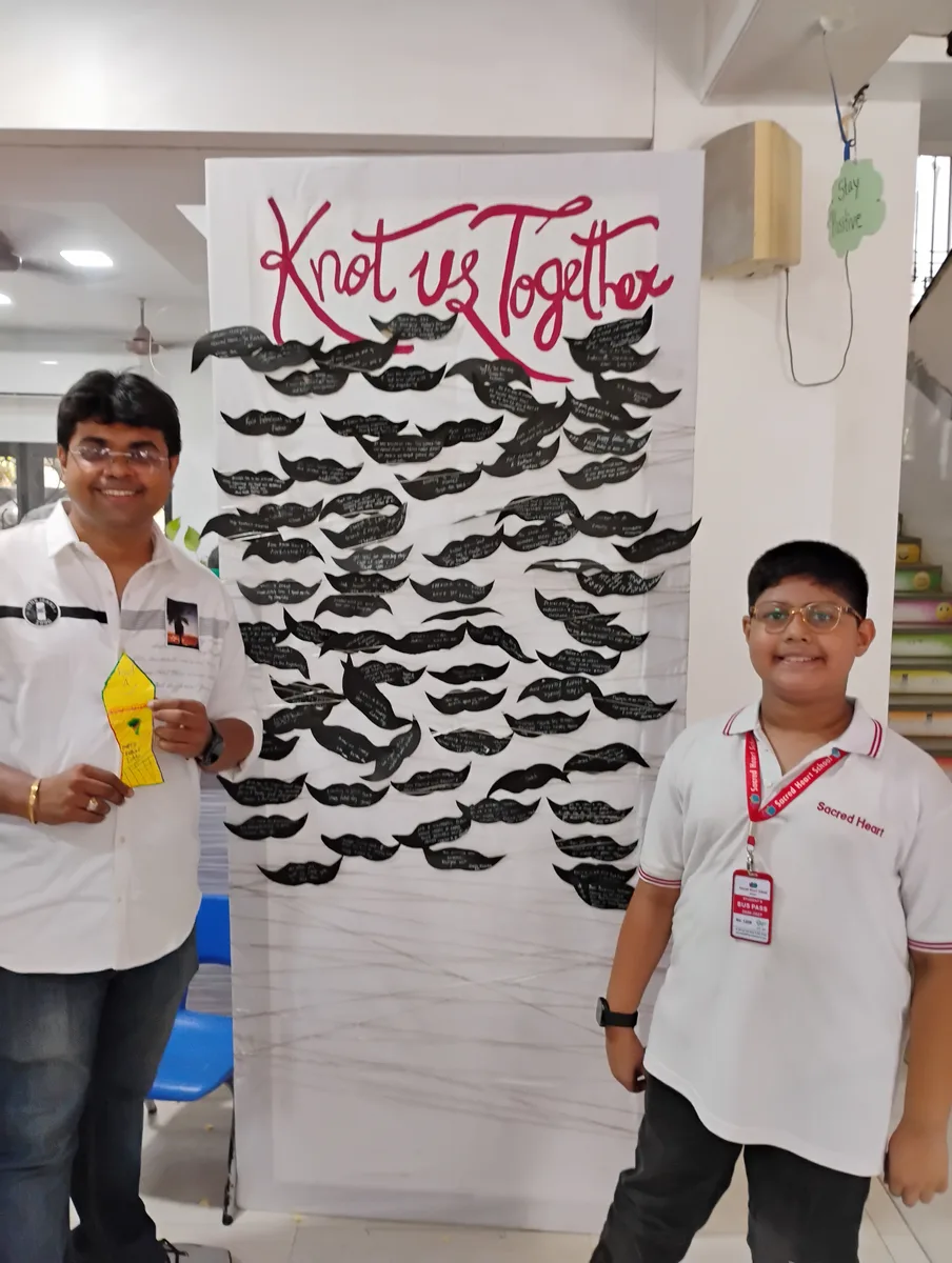 A father and child in front of the Knot Us Together installation