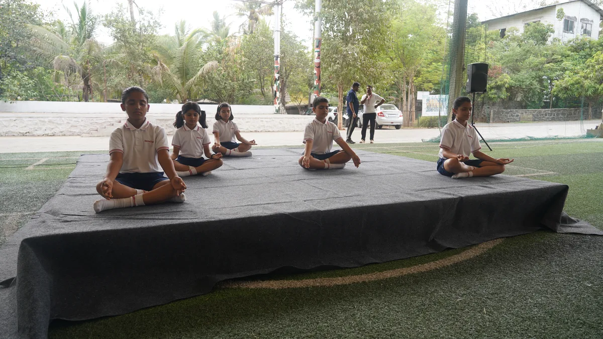 Primary students practising yoga on a raised platform