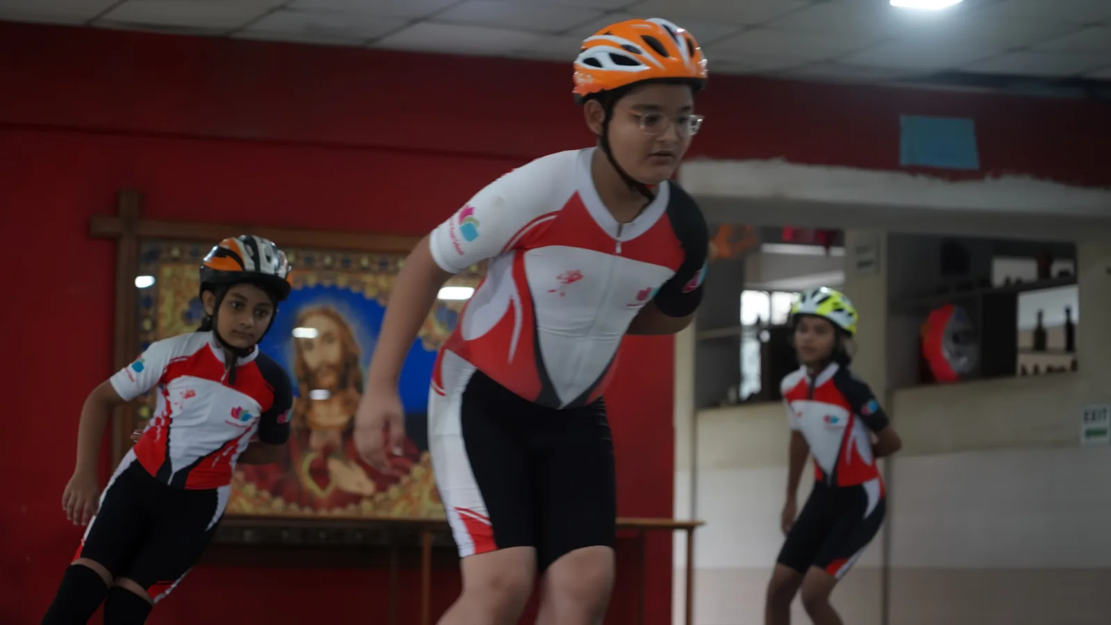 A student skating with a helmet on the indoor rink