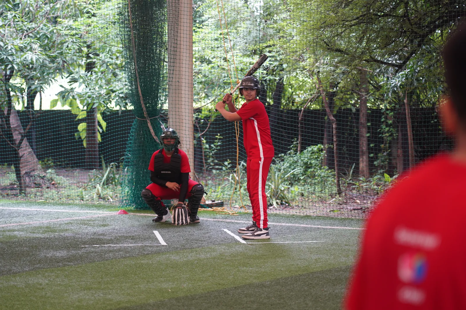 A student batting during a baseball session
